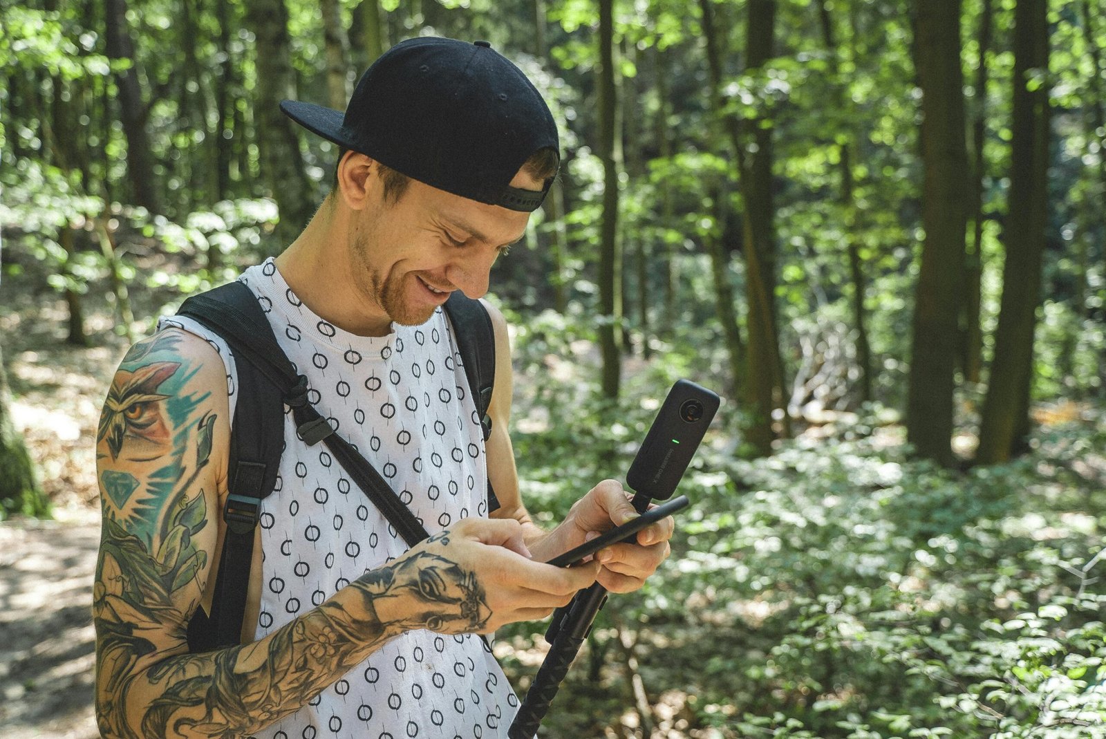 A person using a camera in a sunlit forest in Berlin, Germany, enjoying nature and exploration.